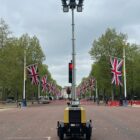 Mobile lighting tower with UK flags in background